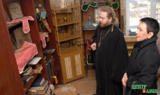 Priest Vyacheslav showing Larisa Shoygu ecclesiastical books and icons of Saint Trinity Church of Kyzyl, March 27, 2008